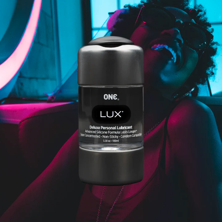 ONE Condoms Lux Lubricant featured on a background of a person smiling and leaning back.
