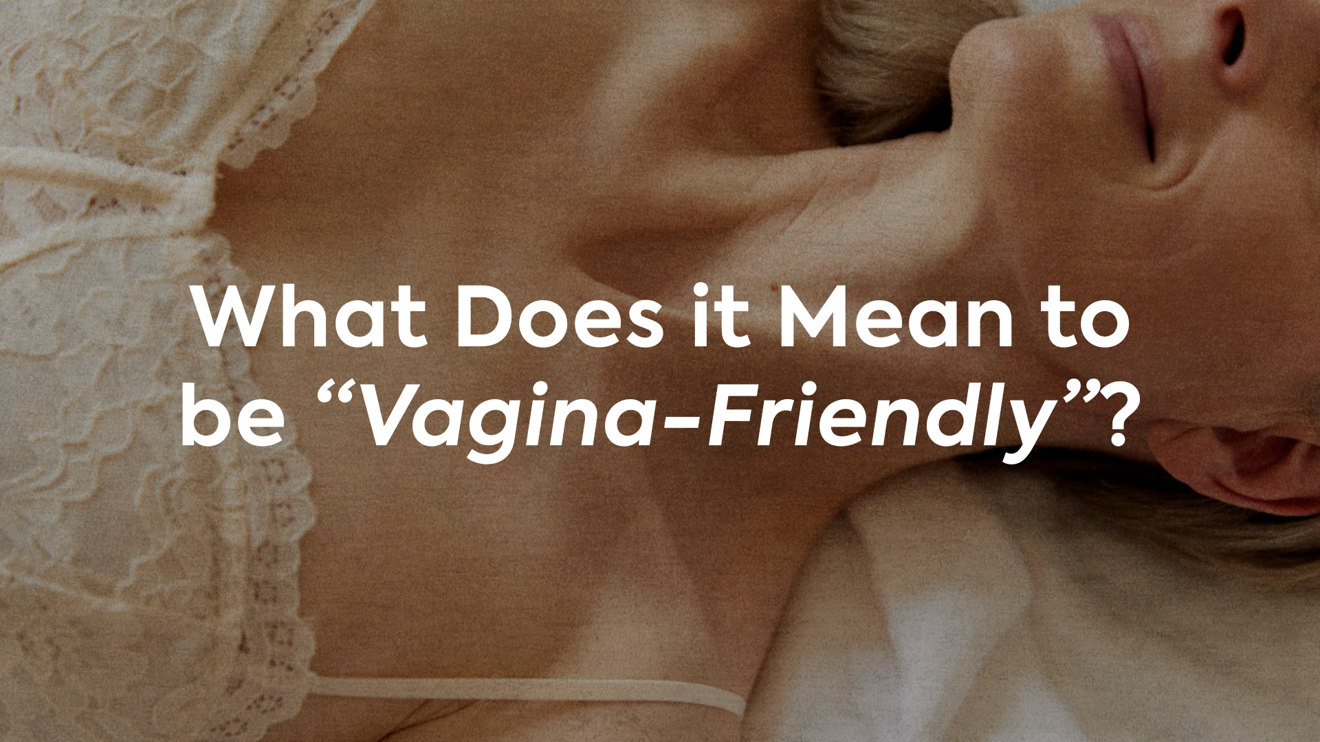 Blog cover for 'Condoms That Are Vagina-Friendly": image of woman happy in bed with text "What Does it Mean to be Vagina-Friendly"?