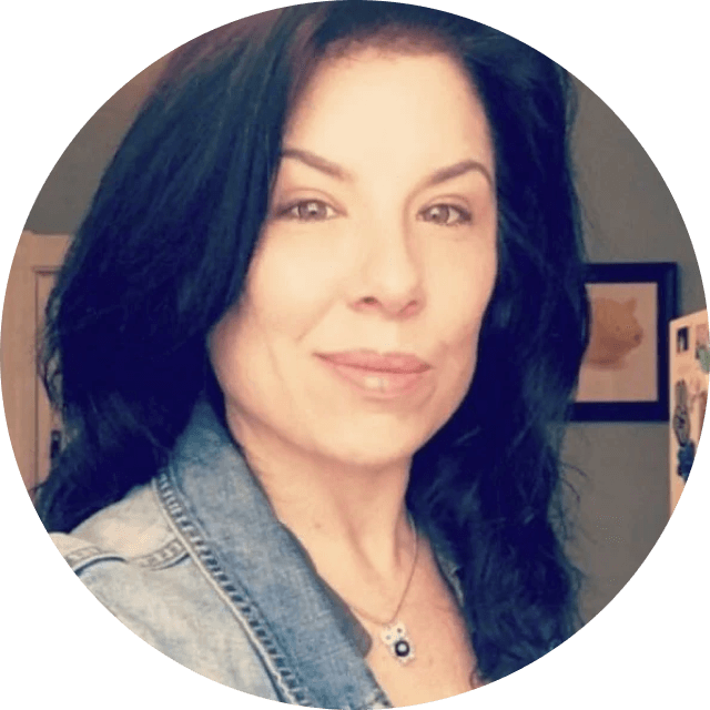 Woman with dark hair wearing a denim jacket indoors