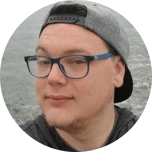 Person wearing a cap and glasses with a blurred background