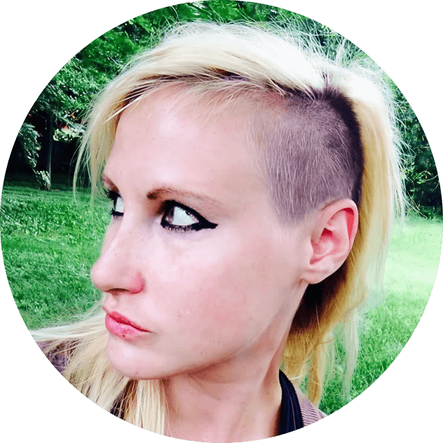 Woman with a shaved head and blonde ponytail outdoors